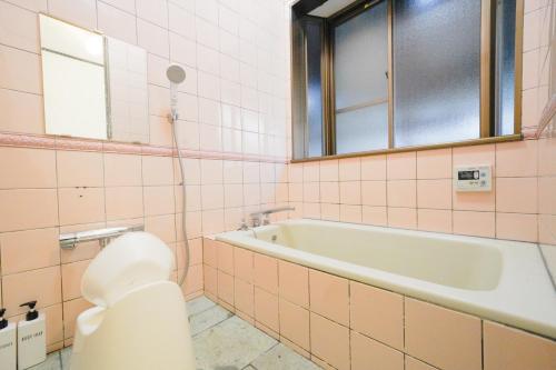 a bathroom with a bath tub and a toilet at Hideaway Hakone Sengokuhara in Sengokuhara