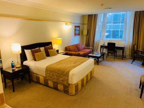 a hotel room with a bed and a living room at Royal Albert Hotel in Brisbane