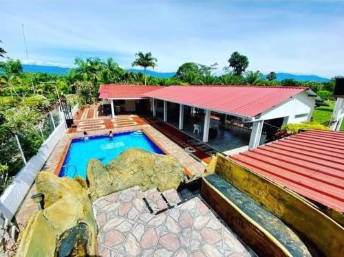 a house with a swimming pool next to a building at Finca Turística VILLA NELLA in Acacías
