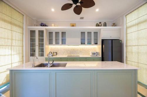 a kitchen with a sink and a refrigerator at Hana Village Garden Tropical Bãi Khem in Phú Quốc