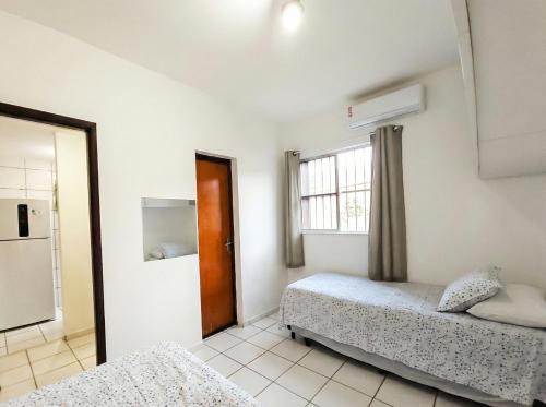 a bedroom with two beds and a window at Apt Graphos Turu - 2 Ar, piscina, completo in São Luís