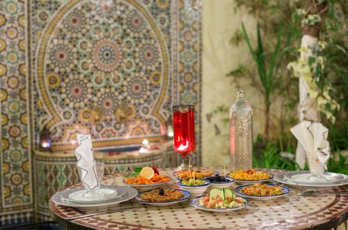 a table with many plates of food on it at Riad Jardin Chrifa in Fès