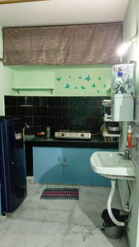 a kitchen with a sink and birds on the wall at Seabeach rest and nest in Puri