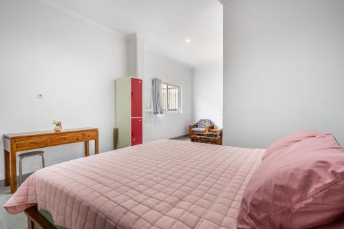a bedroom with a pink bed and a desk at The Twenty Eight in Ungasan