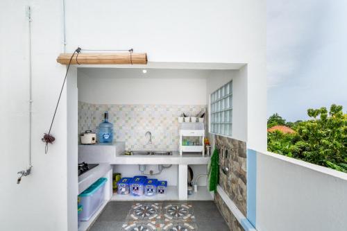 a small kitchen with white counters and a sink at The Twenty Eight in Ungasan