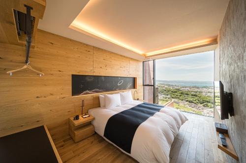 a bedroom with a large bed with a large window at SEKIYA RESORT Galleria Midobaru in Beppu