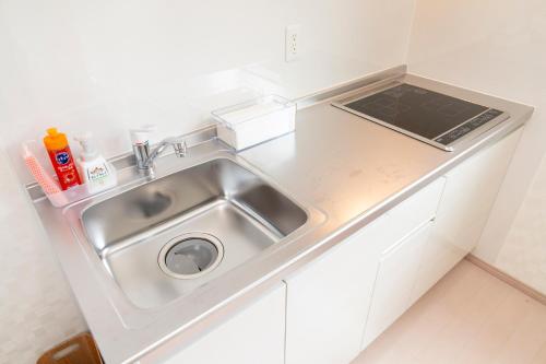 a kitchen with a sink and a counter top at air駅前民泊 in Izumi-Sano