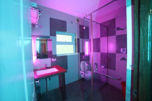 a pink bathroom with a sink and a shower at Kangs Nirvana Resorts and Spa in Hoshiārpur