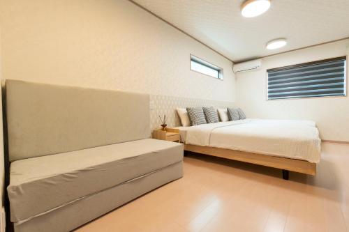 a bedroom with two beds and a window at air駅前民泊 in Izumi-Sano