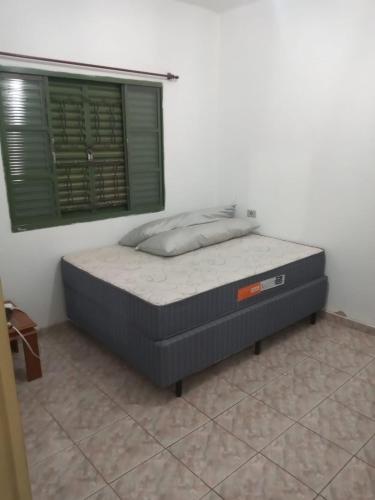 a bed in a room with a window at Chácara Seu Antônio in Mombuca