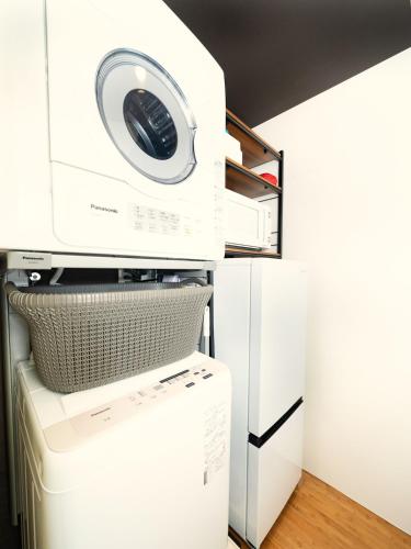a washer and dryer stacked on top of a refrigerator at 旅鴉 inn 高松 - 高松駅徒歩5分 in Takamatsu