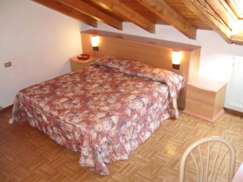 um quarto com uma cama e piso em madeira em Hotel Europa em Peio Fonti