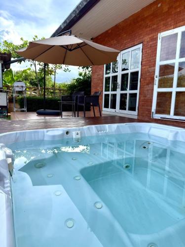 a hot tub with an umbrella in a yard at ที่พักสงขลา Homy garden Songkhla in Ban Khao Rup Chang