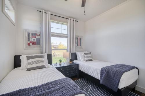 two beds in a room with a window at 2 BR King Bed Hot Tub AC Near Jackson in Victor