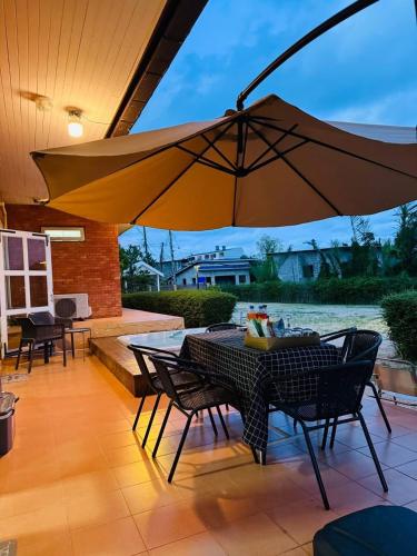 a patio with a table and a large umbrella at ที่พักสงขลา Homy garden Songkhla in Ban Khao Rup Chang