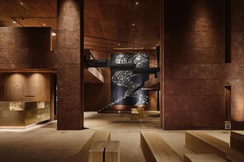 a lobby of a building with a staircase and a wall at SEKIYA RESORT Galleria Midobaru in Beppu