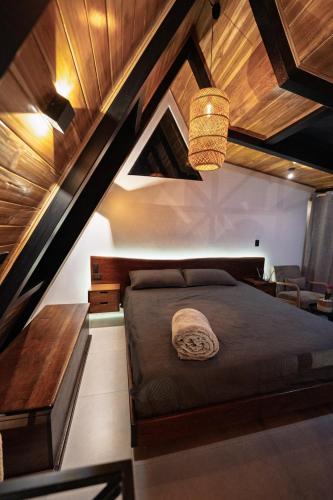 a bedroom with a bed and a wooden ceiling at Luxury AFrame with Private Jacuzzi Poás Volcano in Vara Blanca