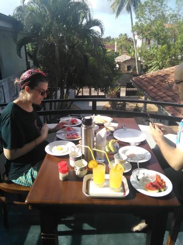 un gruppo di persone sedute a un tavolo con del cibo di Villa Rodrigo a Negombo