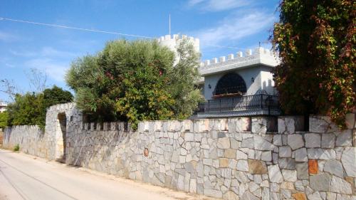 a stone retaining wall next to a road at Castle By The Sea in Artemida
