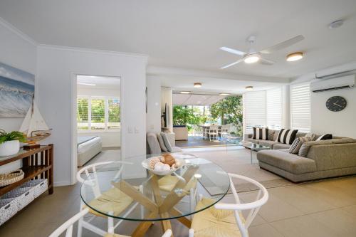 a living room with a glass table and a couch at #2 Hastings Street in Noosa Heads