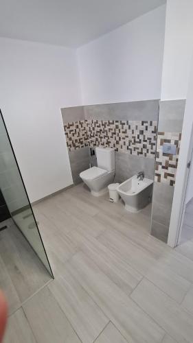a bathroom with two toilets and a sink at a SPECIAL place in Los Cristianos