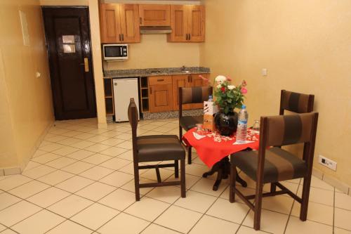 a kitchen with a table and chairs with flowers on it at New Farah Hotel in Agadir