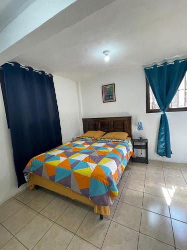 a bedroom with a bed with a colorful comforter at Casa Mama Wela in San Pedro La Laguna