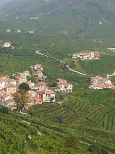 uma pequena aldeia no meio de uma colina verde em A casa di Albino e Giovannina em Conegliano