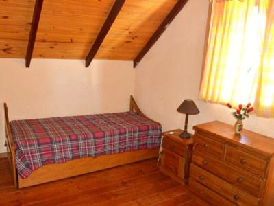 a bedroom with a bed and a dresser and a window at Alquileres en Piriápolis Coriman & Luz de Luna in Piriápolis