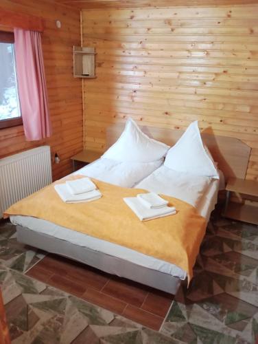 a bedroom with a bed with two towels on it at Casa Arion in Arieşeni