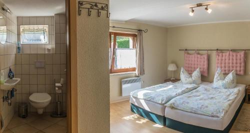 AltendorfにあるFerienhaus Rosalieの大きなベッドとバスルームのある寝室