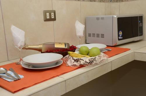 a counter with two plates and a microwave and fruit at Golden Inca Hotel in Cusco