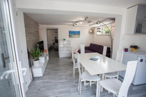 une cuisine et une salle à manger avec une table et des chaises blanches dans l'établissement Villa Sunshine, à Biscarrosse-Plage