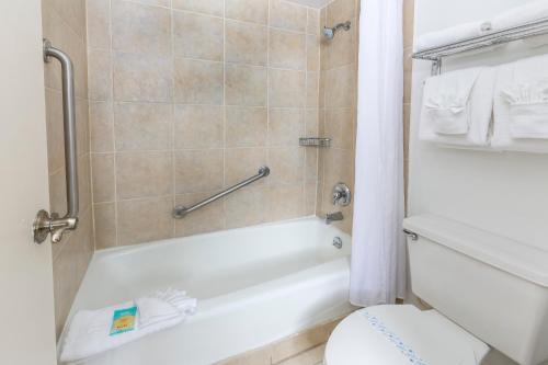 a bathroom with a white tub and a toilet at Flamingo Express Hotel in Kissimmee