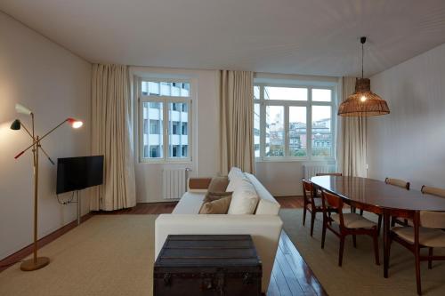 a living room with a white couch and a table at Casas do Rivoli in Porto