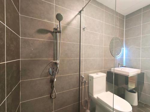 a bathroom with a shower with a toilet and a sink at Sunway Onsen Suites - Theme Park Tambun Ipoh by Ryokan Management in Tambun