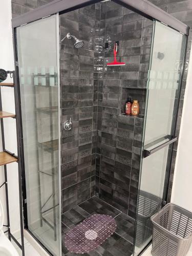a shower with a glass door in a bathroom at Consulado Santa Catarina a 2 min in Monterrey
