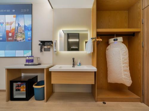 a bathroom with a sink and a mirror at The Screen Hotel Hangzhou East St ation-Zhanongkou Metro in Hangzhou