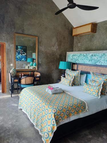 ein Schlafzimmer mit einem großen Bett und einem Schreibtisch in der Unterkunft H616 Vintage Elegance with sea view in Kubutambahan
