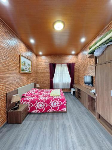 a bedroom with a red bed and a television at Bối Villa Bảo Lộc in Minrong Sekang