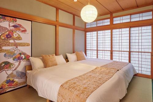 a bedroom with a bed in a room with windows at R STAY Nagoya Atsuta in Nagoya