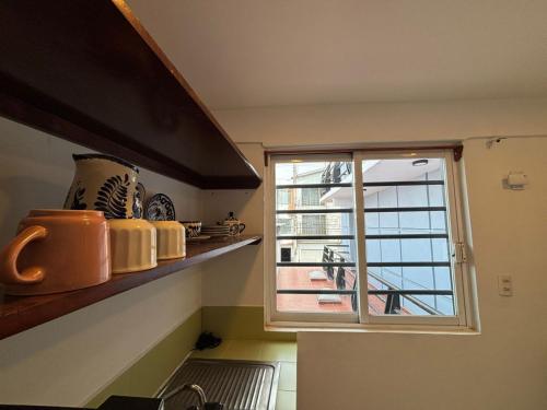 a kitchen with a window with a view of a balcony at Terraza Amecameca 2 in Amecameca de Juárez