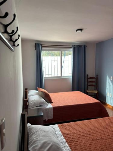 a bedroom with two beds and a window at departamento Terraza Amecameca II in Amecameca de Juárez