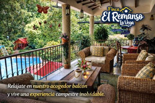 an outdoor patio with chairs and a table and a pool at Finca El Remanso La Vega in La Vega