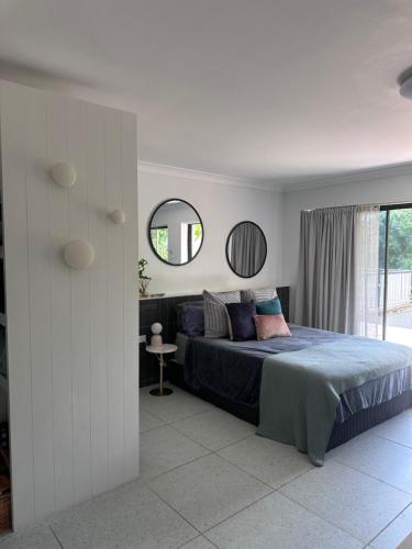a bedroom with a large bed and a mirror at Mediterranean Studio & Garden View Private Pet Friendly in Brisbane