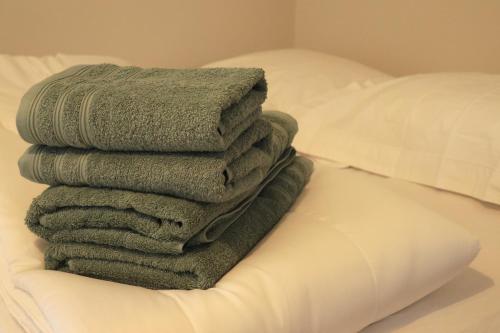 a stack of towels sitting on top of a bed at Studio for 2 people in Bouloc