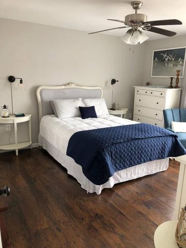 a bedroom with a bed with a blue blanket on it at Waterfront with Heated Pool, Dock & Outdoor Fun ! in Beach Haven West