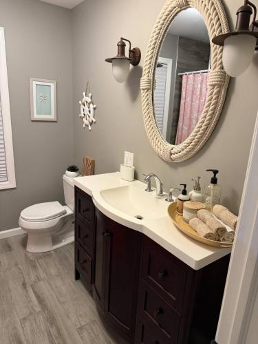 a bathroom with a sink and a mirror at Waterfront with Heated Pool, Dock & Outdoor Fun ! in Beach Haven West