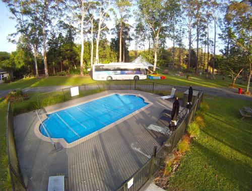 een bus staat geparkeerd naast een zwembad bij Bay of Islands Holiday Park in Paihia