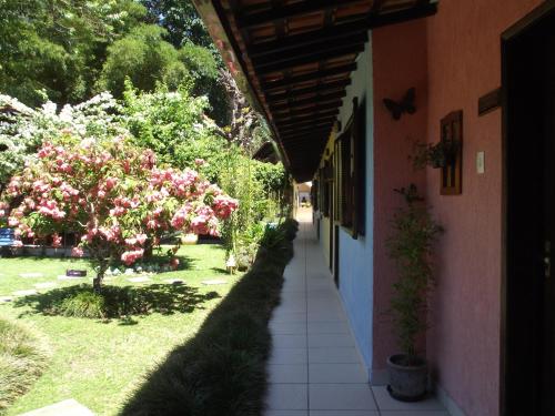 an empty hallway of a house with pink flowers at Pousada Caúca in Abraão